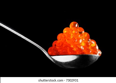 The Spoon With Red Caviar On A Black Background