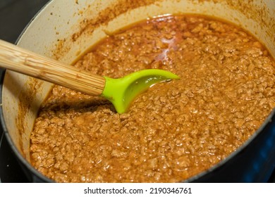 Spoon In Simmering Pot Of Home Made Ragu Or Ragout In Cast Iron Pot On Stove