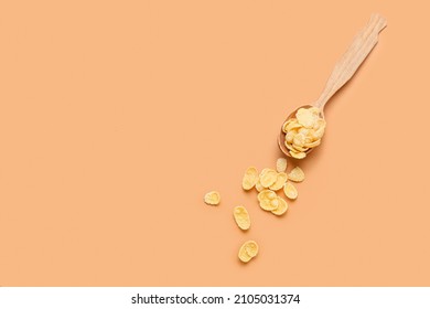 Spoon with tasty cornflakes on color background