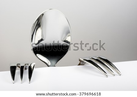 Spoon and two forks formed into conceptual figure