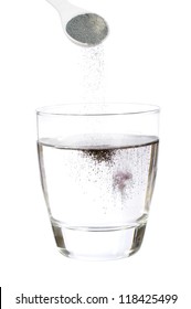 Spoonful Of Powdered Grape Soft Drink Mix Falling Into Glass Of Water Isolated On White