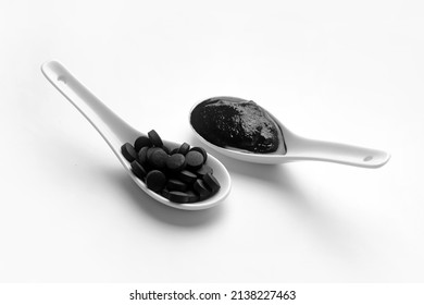 Spoons With Activated Carbon Mask And Pills On White Background