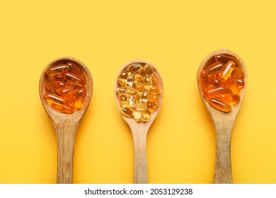 Spoons With Fish Oil Capsules On Color Background