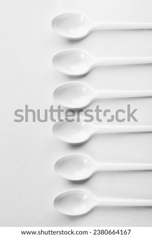 Spoons on a white background. Row of plastic spoons on white.