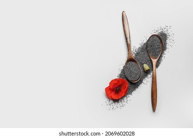 Spoons with poppy seeds and flower on white background
