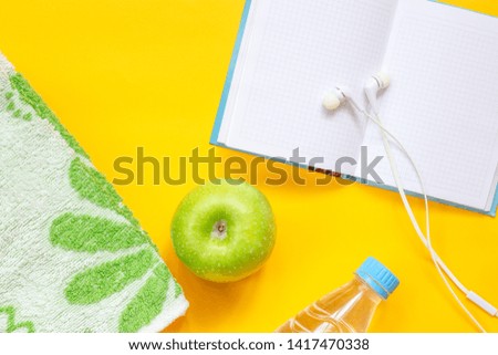 Sport accessories on yellow background. Planning of diet and trainings. Dieting. Healthy lifestyle. Female fitness. Slimming. Flat lay. Top view.