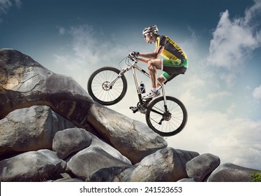 Спортивный фон. Велосипедист восхождение на скалу.