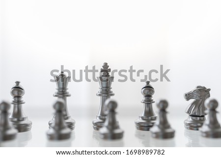 Sport board game, Business and planning concept. Closeup of King, Queen, Bishop, knight and pawn silver chess pieces on glass table.