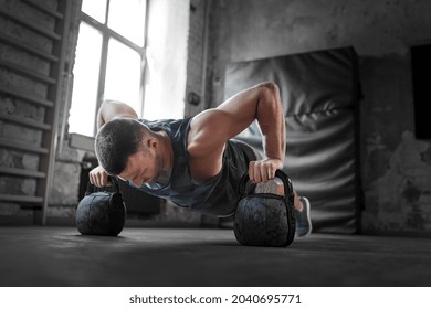 Sport, Bodybuilding, Fitness And People Concept - Young Man Doing Kettlebell Push-ups In Gym