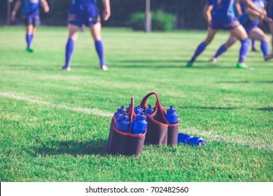 Sport bottles of fresh water energy drink on football rugby field grass - Powered by Shutterstock