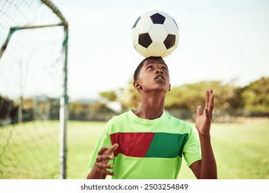 Sport, boy and ball on head with football on field for balance, trick practice and exercise for competition match. Soccer player, person and playing with header for coordination training and fitness - Powered by Shutterstock