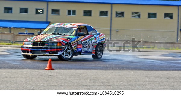 Sport car. Competition. Drift training.\
Sport vehicle in drift on asphalt road close to a training cone.\
Active lifestyle. Belarus, Minsk - August 10,\
2016