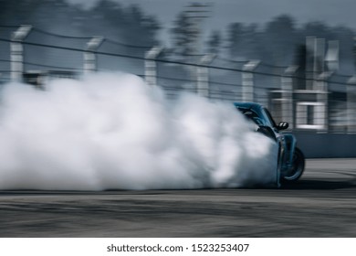 Sport Car Go Very Fast At The Corner With A Clouds Of Smoke. Car Make A Drift At The Racetrack