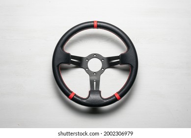 A Sport Car Steering Wheel On The White Flat Lay Background.