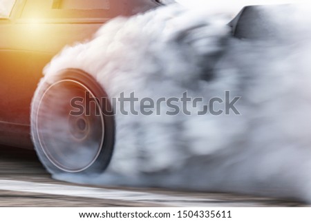 Sport car wheel drifting, Car drifting, Blurred  image diffusion race drift car with lots of smoke from burning tires on speed track.