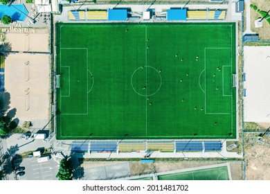 Sport Center During Training Of The Football Team. Players Are Playing A Soccer Match. Aerial Top View In Summer Day.