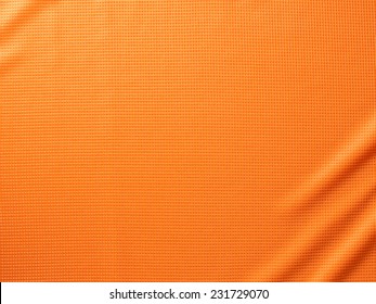 Sport Clothing Fabric Texture Background. Top View Of Cloth Textile Surface. Orange Football Shirt. Text Space