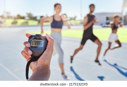 A sport coach timing athletes progress using a stopwatch. .Blurred athletes racing towards finish line and breaking the record. Stopwatch measuring time for a marathon at a sports event. - Powered by Shutterstock