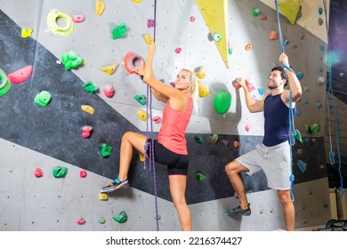 Sport Concepts And  Ideas. Joyful Couple Climbing Up The Wall Together. Horizontal Image Orientation