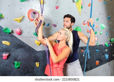 Sport Concepts. Sporty Joyful Couple Climbing Up The Wall Together As Bouldering Concepts. Horizontal Image