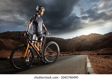 Sport. The cyclist rides on his bike at sunset. Dramatic background.
