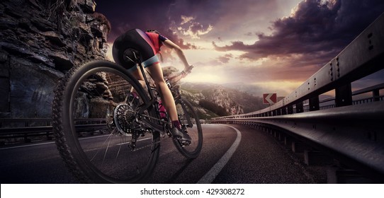 Sport. Cyclist riding a bike on an open road to the sunset