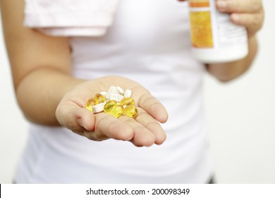 Sport And Diet Concept - Woman Hand With Vitamins And Medication