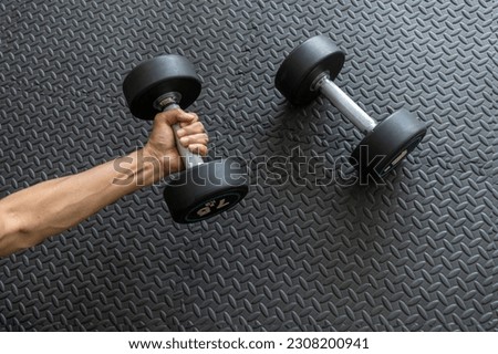 Sport Equipment Concept. close up of  Male Athlete Taking Dumbbell At Gym, Closeup Shot Of Arm and dumbell , Preparing For Bodybuilding Workout, Cropped