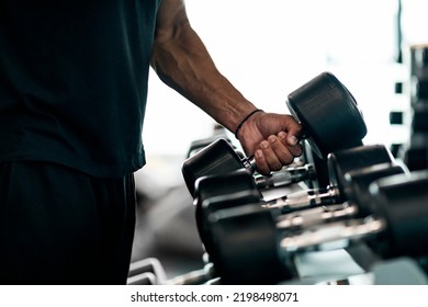 Sport Equipment Concept. Unrecognizable Black Male Athlete Taking Dumbbell From Rack At Gym, Closeup Shot Of African American Man Choosing Barbells, Preparing For Bodybuilding Workout, Cropped - Shutterstock ID 2198498071