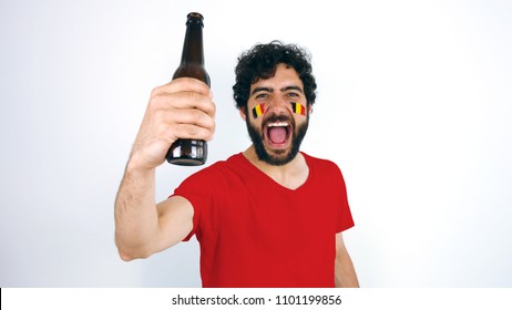 Sport fan holding a beer screaming for the triumph of his team. Man with the flag of Belgium makeup on his face and red t-shirt.
 - Powered by Shutterstock