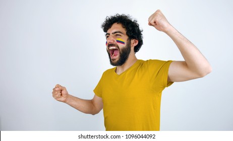 Sport fan screaming for the triumph of his team. Man with the flag of Colombia makeup on his face and yellow t-shirt.
        - Powered by Shutterstock