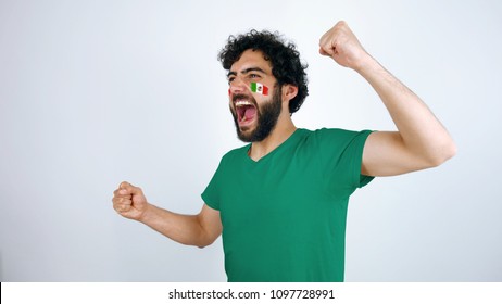 Sport fan screaming for the triumph of his team. Man with the flag of Mexico  makeup on his face and green t-shirt.
        - Powered by Shutterstock