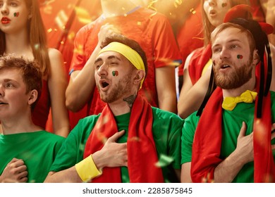 Sport fans emotionally cheering up favourite football, soccer team of portugal at stadium during game, singing anthem. Concept of sport, competition, championship, emotions, hobby and entertainment - Powered by Shutterstock