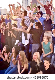 Sport Fans Hands Up And Singing On Tribunes. Group People In Sport.