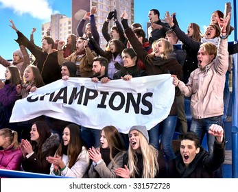 Sport Fans Holding Champion Banner  And Singing On Tribunes. Group People.