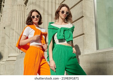 Sport fashion, sport casual style. Beautiful female models poses in bright sports suits and sunglasses on the city street. Fashion shot. - Shutterstock ID 2198391871