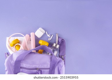 Sport and fitness background. Women's sports bag with dumbbells, bottle of water, towel, jump rope, headphones, accessories for sports and fitness on light purple background, copy space - Powered by Shutterstock