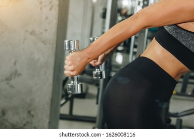 sport, fitness, bodybuilding, weightlifting and people concept - close up of woman flexing arms with dumbbell in gym