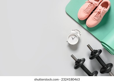Sport and fitness equipment, female pink shoes, timer, dumbbells, yoga mat on gray background. View from above. Copy space. - Powered by Shutterstock