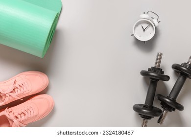 Sport and fitness equipment, female pink shoes, timer, dumbbells, yoga mat on gray background. View from above. Copy space. - Powered by Shutterstock