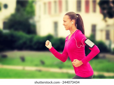 sport, fitness, health, technology and people concept - smiling young african american woman running with smartphone and earphones outdoors - Powered by Shutterstock