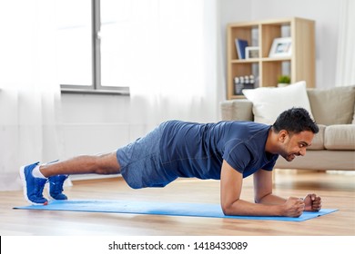 Sport, Fitness And Healthy Lifestyle Concept - Man Doing Plank Exercise At Home