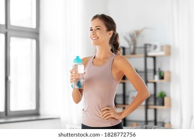 sport, fitness and healthy lifestyle concept - smiling young woman with bottle of water at home - Powered by Shutterstock