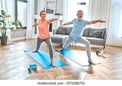 Sport, Fitness And Healthy Lifestyle Concept. Mature Couple Doing Exercise Or Yoga At Home. How To Stay Healthy In Quarantine.