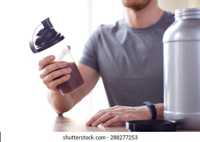 Sport, Fitness, Healthy Lifestyle And People Concept - Close Up Of Man In Fitness Bracelet With Jar And Bottle Preparing Protein Shake