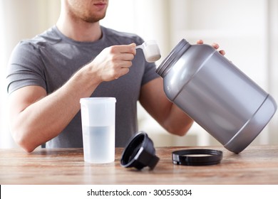 Sport, Fitness, Healthy Lifestyle And People Concept - Close Up Of Man With Jar And Bottle Preparing Protein Shake