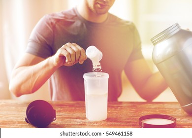 Sport, Fitness, Healthy Lifestyle And People Concept - Close Up Of Man With Jar And Bottle Preparing Protein Shake