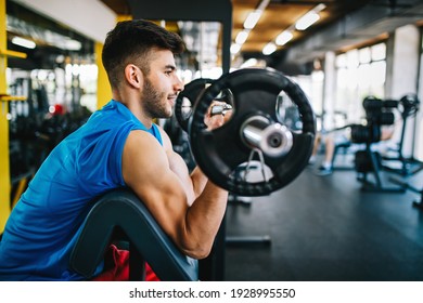 Sport, fitness, lifestyle and people concept. Happy fit man exercising with dumbbells in gym - Powered by Shutterstock