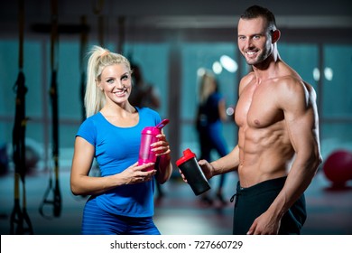 Sport, Fitness, Lifestyle And People Concept - Smiling Man And Woman With Protein Shake Bottle Talking In Gym