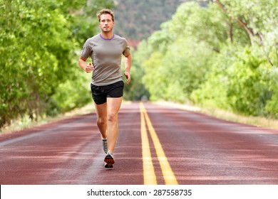 Sport And Fitness Runner Man Running On Road Training For Marathon Run Doing High Intensity Interval Training Sprint Workout Outdoors In Summer. Male Athlete Sports Model Fit And Healthy Aspirations.